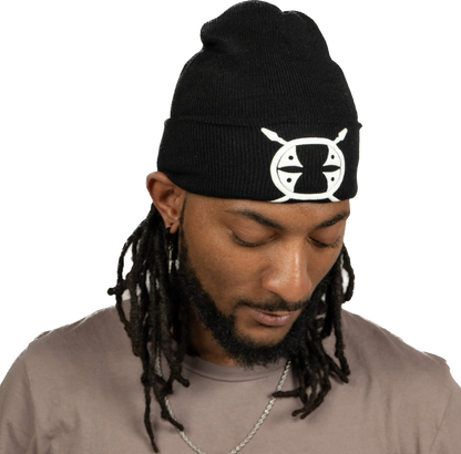 male model looking down wearing a black Schleepwear logo beanie.